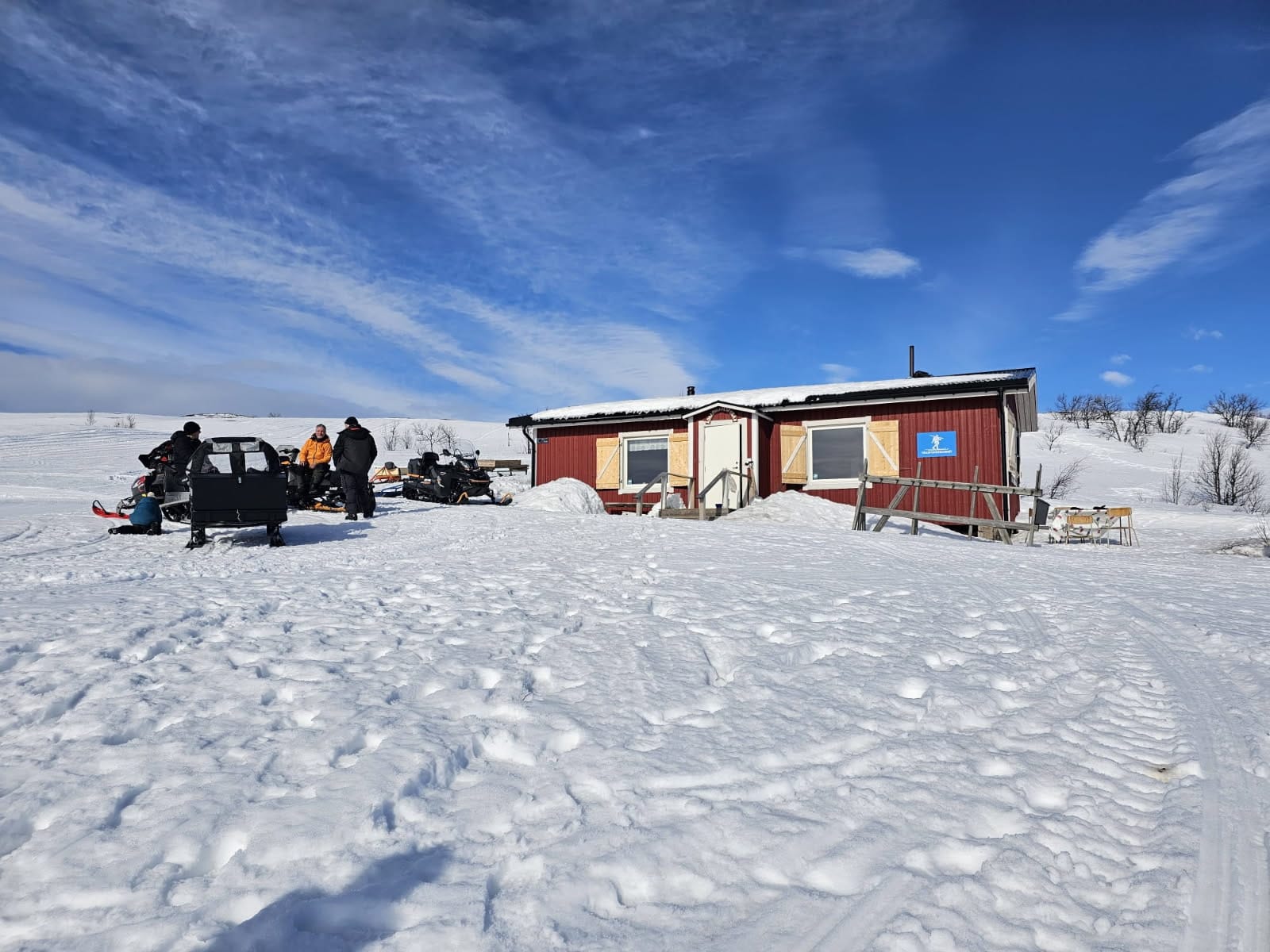 Fotot visar stugan med några skotrar framför.