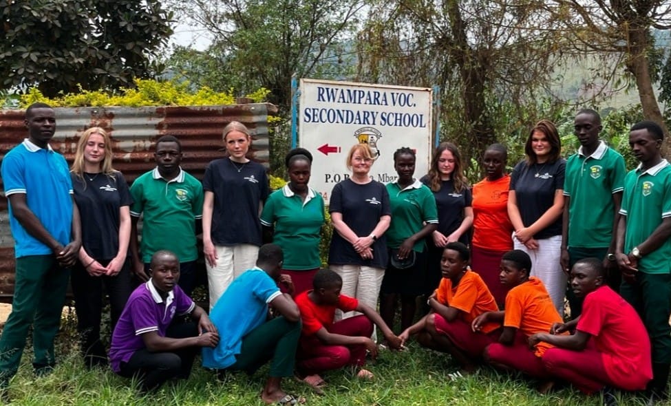 Foto på deltagarna framför skolan.