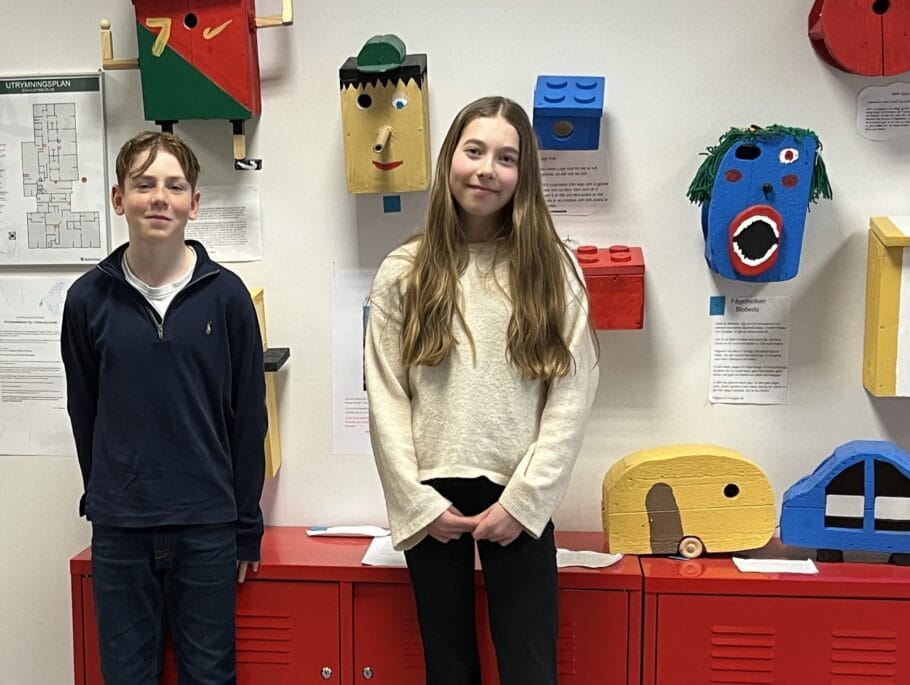 Foto på de två vinnarna framför en vägg med de olika bidragen.