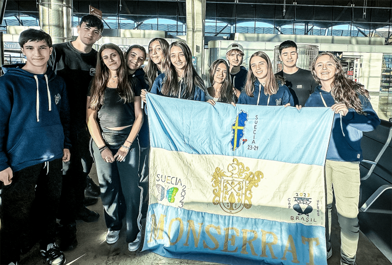 De argentinska eleverna står på flygplatsen och håller upp en argentinsk banderoll med Sveriges flagga inritad.