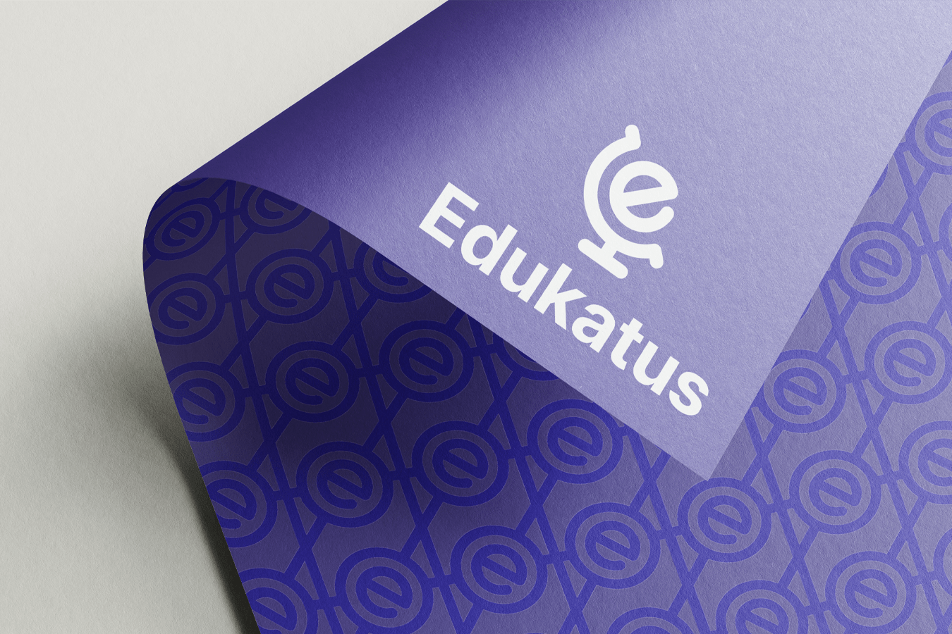 Mockupbild på ett lila blad med Edukatus logotyp i vitt.