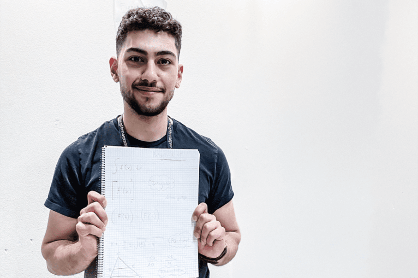 Artin Bagher, står med ett block framför sig. Toppeleven driver ett företag som vill stötta elever till bättre pluggande.