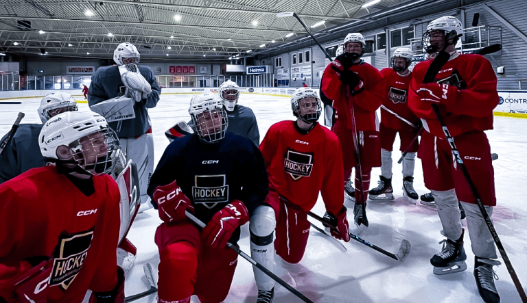Hockeyelever på idrottsprofilen står på isen.