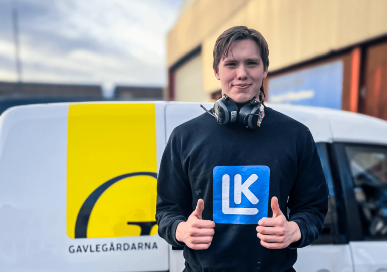 Jonathan Svardström ger två timmar upp framför firmabilen. Han är iklädd svarta yrkeskläder.