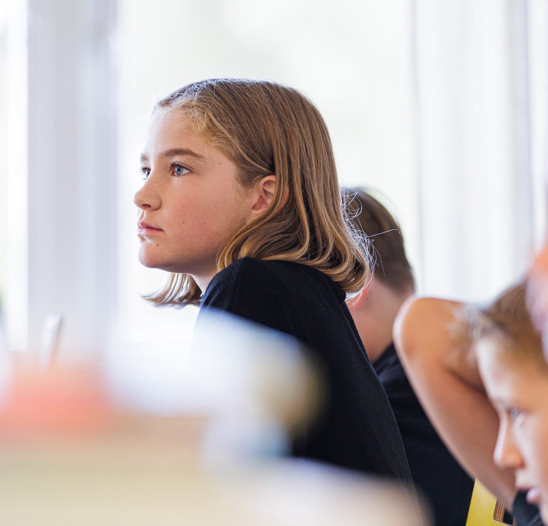 Elev sitter i klassrum och lyssnar.