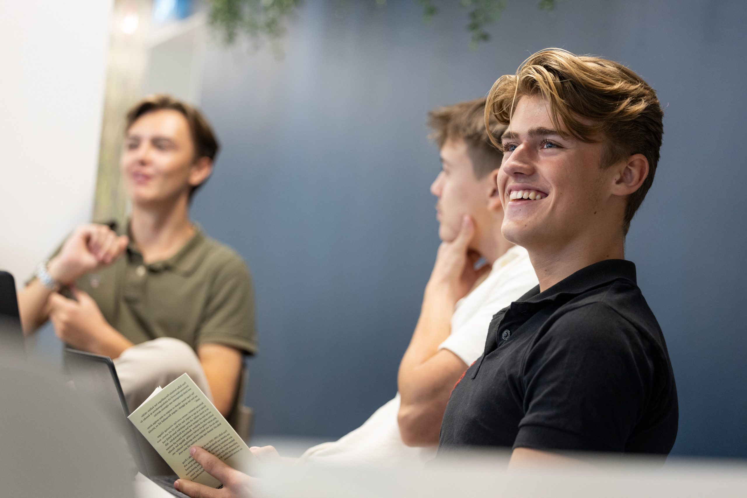 Gymnasieelev sitter i klassrum och lyssnar.