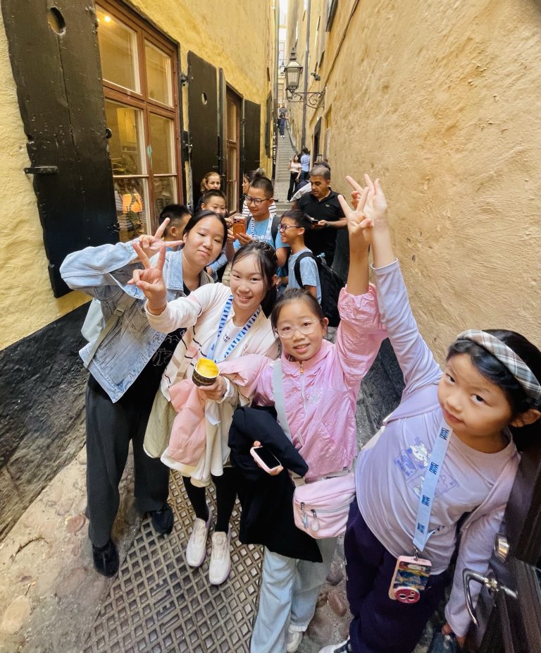 Foto på de kinesiska eleverna i en gränd i Gamla stan i Stockholm.