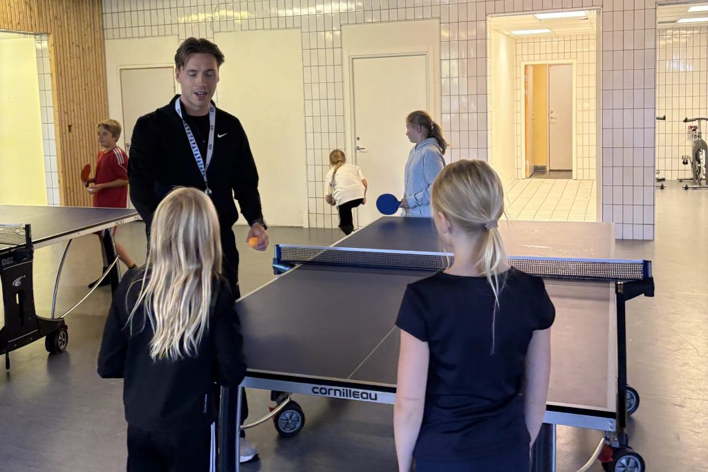 Foto på barn och en lärare kring ett pingisbord.