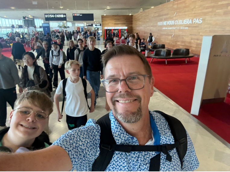 Foto på läraren och eleverna på väg på en flygplats.
